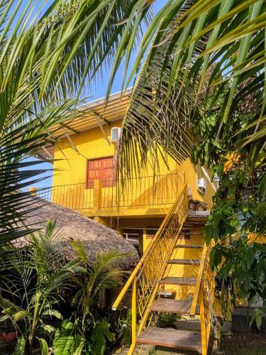 a yellow house with a staircase leading up to it at POUSADA FLORA in Alter do Chao