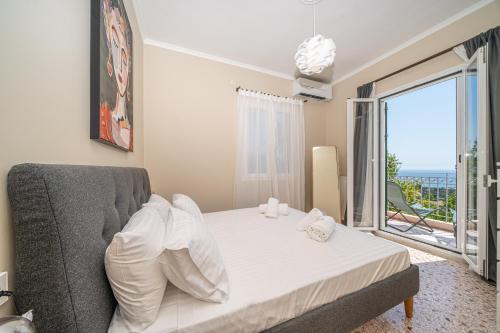 a bedroom with a bed and a large window at Thea Sea View Kefalonia in Sarlata