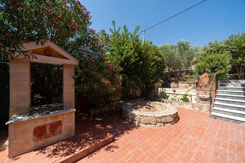 a backyard with a brick patio with stairs and trees at Thea Sea View Kefalonia in Sarlata