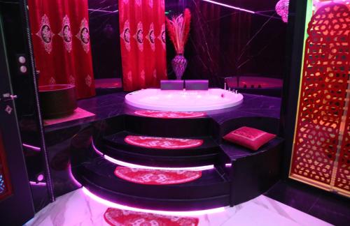 a red and black bathroom with a tub and red curtains at Sheherazade in Lyon