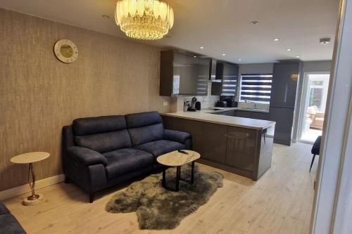a living room with a couch and a kitchen at Liverpool House Near City Centre in Liverpool