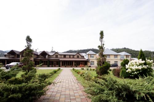 a house with a brick walkway in front of a yard at Hotel Duet in Maydan