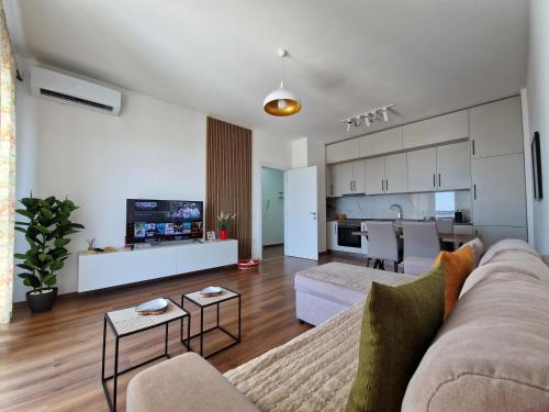 ein Wohnzimmer mit Sofa und eine Küche in der Unterkunft Red & White Palace Apartment in Tirana