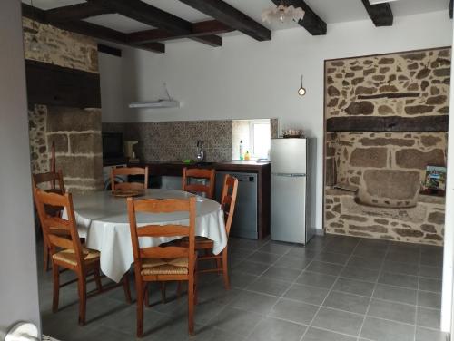 une cuisine et une salle à manger avec une table et des chaises dans l'établissement Gîte accessible à la campagne, à Orliac-de-Bar