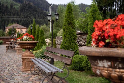 a park bench and flowers in a garden at Hotel Duet in Maydan