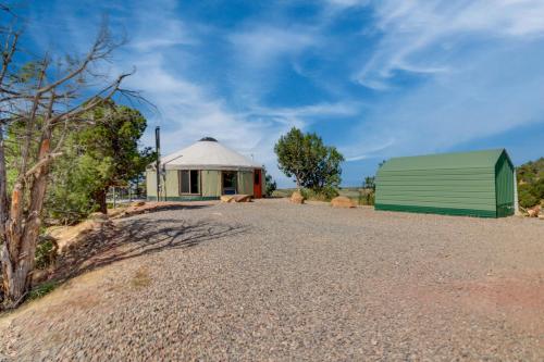 a building with a tent and a gravel road at Mountainside Yurt with Views Less Than 3 Mi to Black Canyon! in Montrose