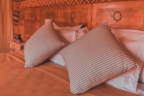 a bed with two pillows on top of it at Aman Agafay in Guertsdar