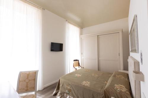 a bedroom with a bed and a tv on a wall at Suite Piazza del Popolo in Ascoli Piceno