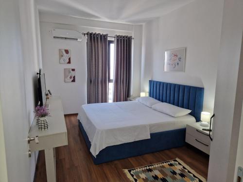 ein Schlafzimmer mit einem blauen Bett und einem Fenster in der Unterkunft Red & White Palace Apartment in Tirana