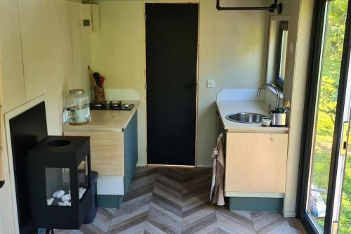 une petite cuisine avec un évier et une cuisinière dans l'établissement Le petit nid des Mésanges, à Volckerinckhove