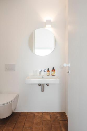 a white bathroom with a sink and a toilet at Vagar do Pastor in Alandroal