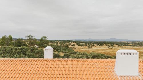 an orange roof with two white chimneys on top of it at Vagar do Pastor in Alandroal