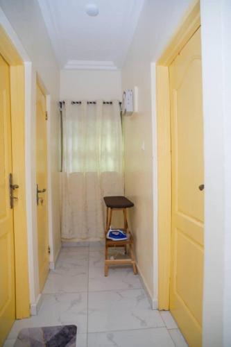 a hallway with a wooden chair in a room at BH Apartment in Kasoa