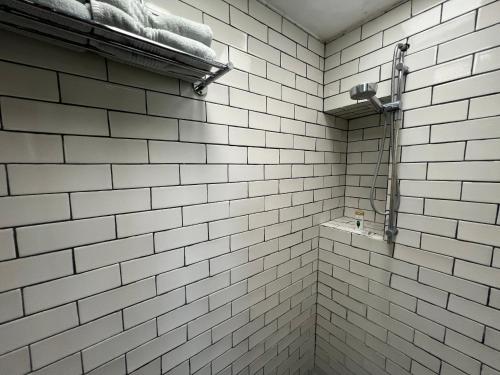 a white tiled bathroom with a towel on a shelf at CASA MAC San Miguel de Allende in San Miguel de Allende