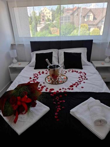 a bed with a table with flowers and a cup on it at Apartamenty Chęciny in Chęciny
