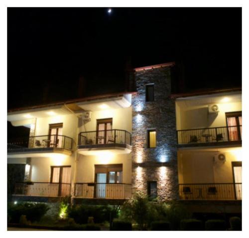 a large white building with balconies and lights at Ydraktis in Órma