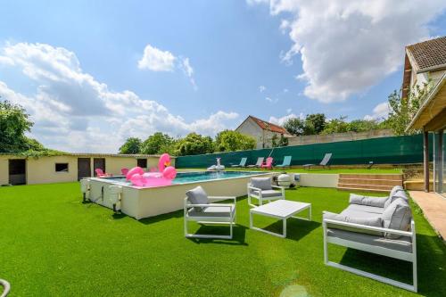 a backyard with a pool and green grass at Villa ballon d or in Goussainville