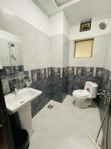 Un baño con lavabo e inodoro en Elegant 2 Bed Apartment Tranquil Stays, en Islamabad