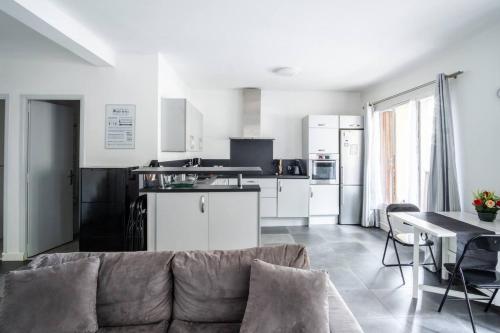 un salon avec un canapé et une cuisine dans l'établissement PASTEUR - Bel appartement familial Pharo -plage des Catalans, à Marseille
