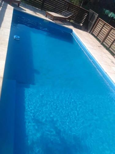 une piscine avec de l'eau bleue dans une maison dans l'établissement Cabañas La Mimi, à Villa Anizacate