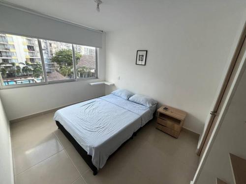 a small bedroom with a bed and a window at Fabuloso Apto Club House Piscina Sauna Turco y mucho más in Ricaurte