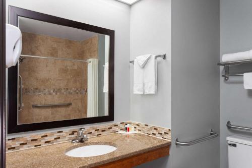 a bathroom with a sink and a mirror at Super 8 by Wyndham Sun Prairie/Madison E in Sun Prairie