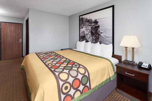 a hotel room with a large bed in a room at Super 8 by Wyndham Sun Prairie/Madison E in Sun Prairie