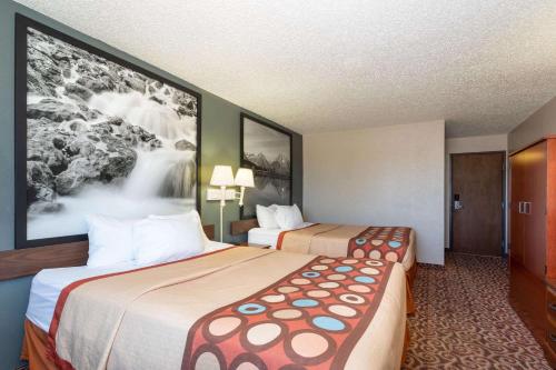 a hotel room with two beds and a large picture at Super 8 by Wyndham Gillette in Gillette