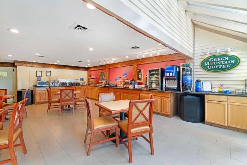 a restaurant with a table and chairs and a counter at Best Western Inn & Suites Rutland-Killington in Rutland