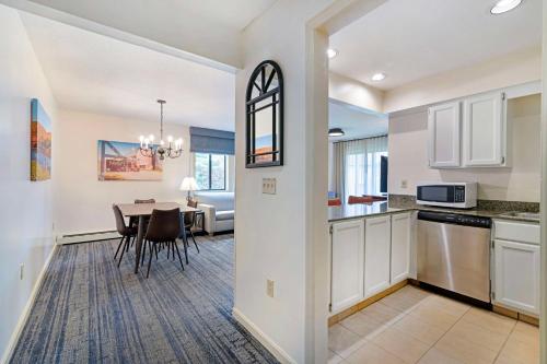a kitchen and dining room with a table and a living room at Best Western Inn & Suites Rutland-Killington in Rutland