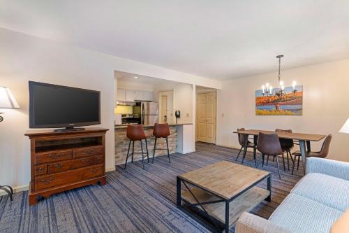 a living room with a couch and a tv and a table at Best Western Inn & Suites Rutland-Killington in Rutland