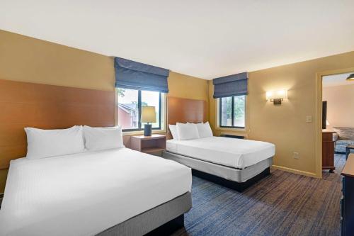 a hotel room with two beds and two windows at Best Western Inn & Suites Rutland-Killington in Rutland