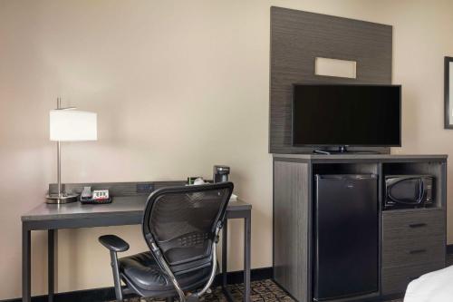 a hotel room with a desk with a television and a chair at Best Western Carthage Inn & Suites in Carthage