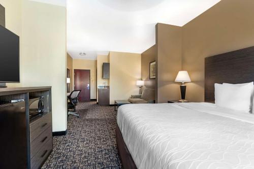 a hotel room with a large bed and a television at Best Western Carthage Inn & Suites in Carthage