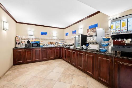 a large kitchen with wooden cabinets and appliances at Best Western Intracoastal Inn in Jupiter