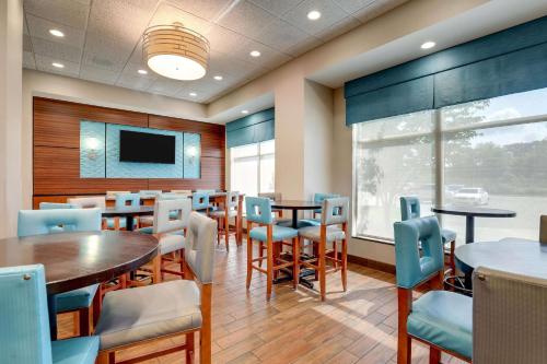 a dining room with tables and chairs and a tv at Drury Inn & Suites Grand Rapids in Cascade