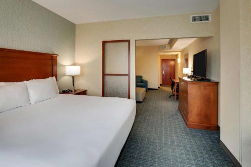a hotel room with a large white bed and a television at Drury Inn & Suites Grand Rapids in Cascade
