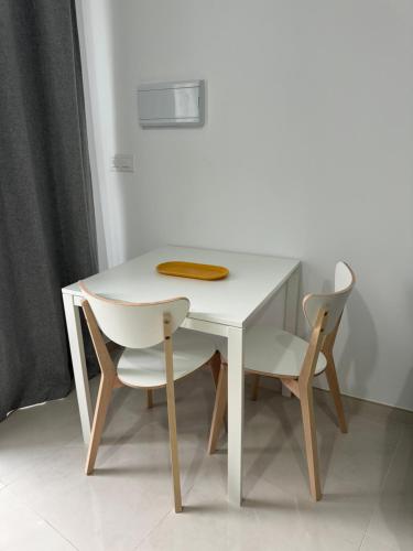 a white table with two chairs and a plate on it at La Casa de Rosita in Fuente del Maestre