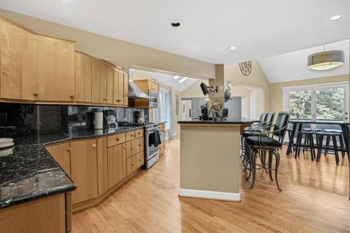 Una cocina con gabinetes de madera y un comedor. en Luxurious Private Lakefront Paradise home, en Mooresville