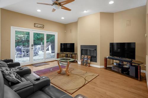 Una sala de estar con un sofá y un televisor de pantalla plana. en Luxurious Private Lakefront Paradise home, en Mooresville