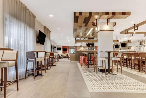 a restaurant with tables and chairs and a bar at Sonesta Anaheim Resort Area in Anaheim