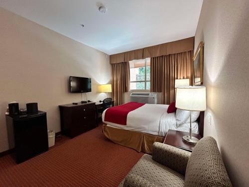 a hotel room with a bed and a couch at SureStay by Best Western Richmond Vancouver Airport in Richmond