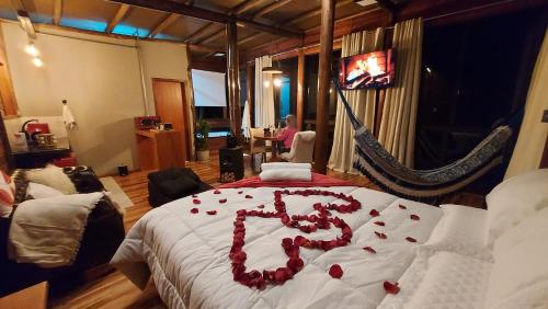 ein Schlafzimmer mit einem Bett mit einem Buchstaben k darauf in der Unterkunft Chalé Luz do Luar Romantismo e uma linda vista in Campos do Jordão