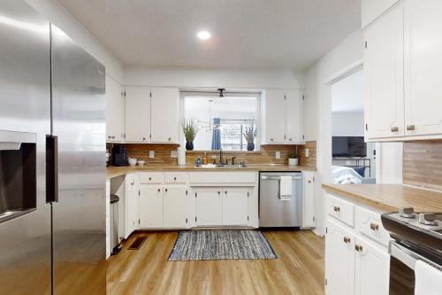 a kitchen with white cabinets and a large window at A Touch of Modern in Hot Springs