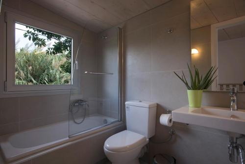 a bathroom with a toilet and a sink and a window at Proimos Apartments in Gerani