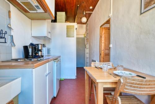 une petite cuisine avec une table en bois, une table et des chaises dans l'établissement Accoules - Charmant appartement au Panier, à Marseille