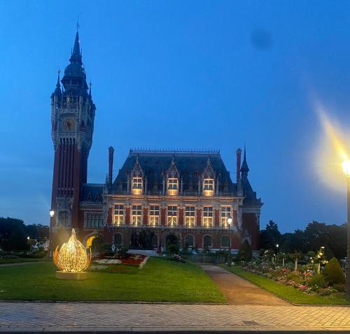 a large building with a clock tower and a large building at Studio cosy et chaleureux in Calais