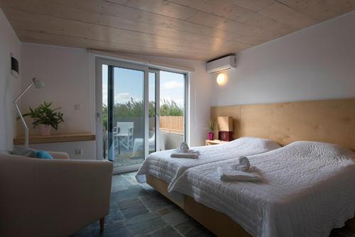 a bedroom with a bed and a large window at Proimos Apartments in Gerani