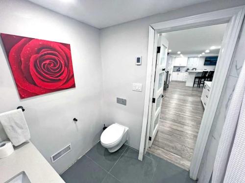 a bathroom with a red rose painting on the wall at Luxe Home Near Limeridge - Sleeps 11 - Pool in Hamilton