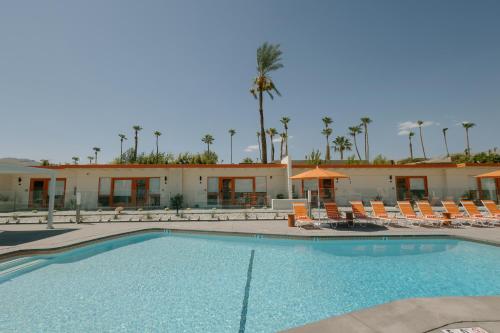 a swimming pool with chairs and a resort at Mojave Resort - Adults Only in Palm Desert